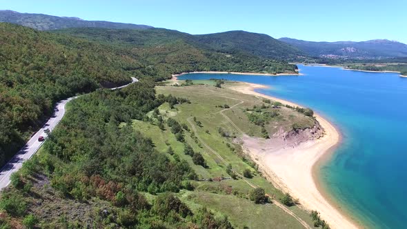 Aerial view of red van driving by artificial lake Peruca, Croatia alt