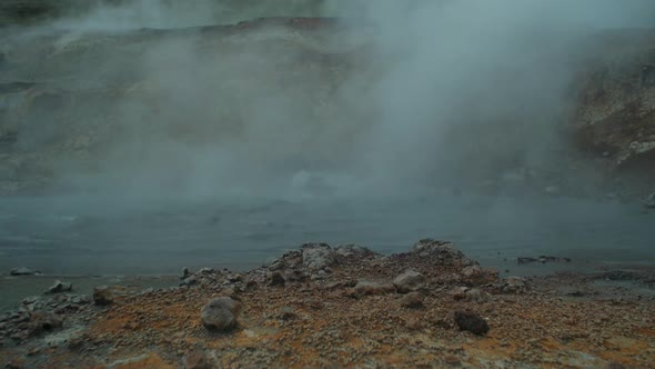 iceland landscape, geothermal hotspring pool steam smoke rising, wide angle shot, camera tilt up