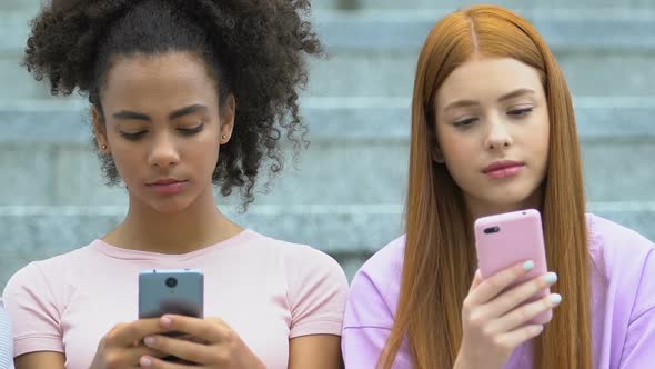 Multiethnic Female Teens Chatting on Smartphones, Real Communication Lack