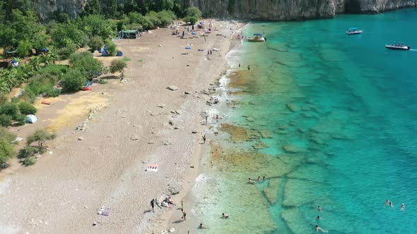 wide aerial of a rural coastal beach along the Mediterranean Sea known as Butterfly Valley in Fethiy