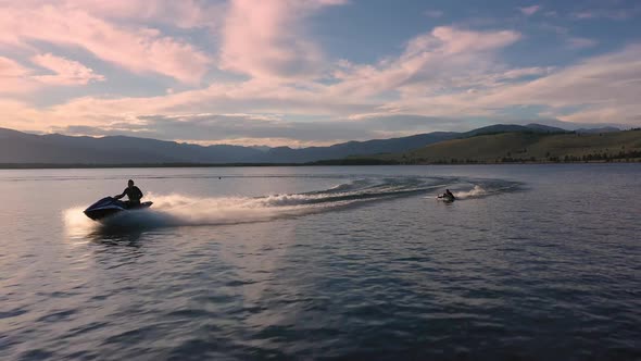 Aerial following a watercraft pulling person behind on a rope