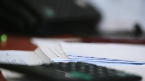 A Man's Hand Uses a Sticker and Fastens Documents with a Stapler.