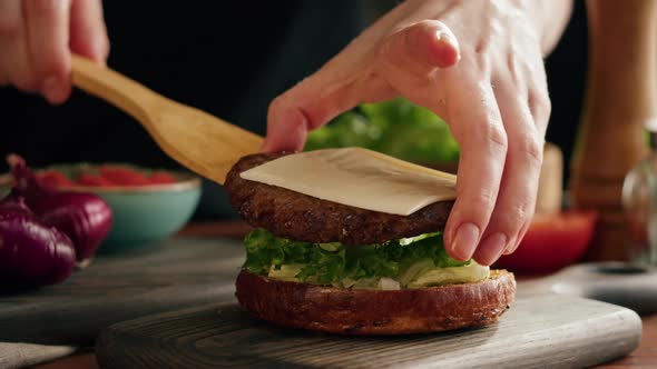 Chef Cooking Burger Putting Meat Chop with Cheese on Lettuce Closeup Making Sandwich Fast Food