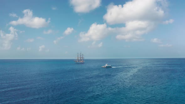 Aerial drone approaching a white ship and a boat in the sea near Bridgetown, Barbados