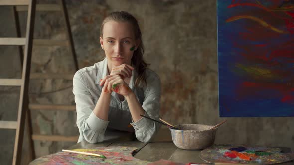 Professional Female Artist Tired of Working in Painting Studio