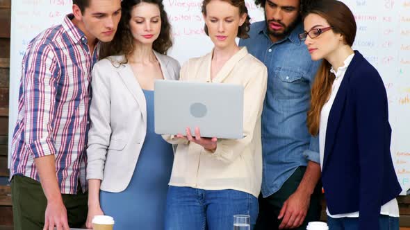 Business executives discussing over laptop in meeting