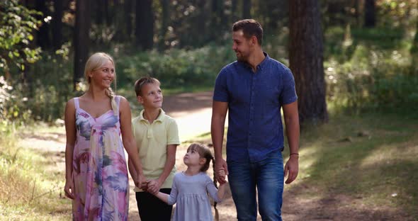 Happy Diverse Family of Four People Walk in Autumn Forest