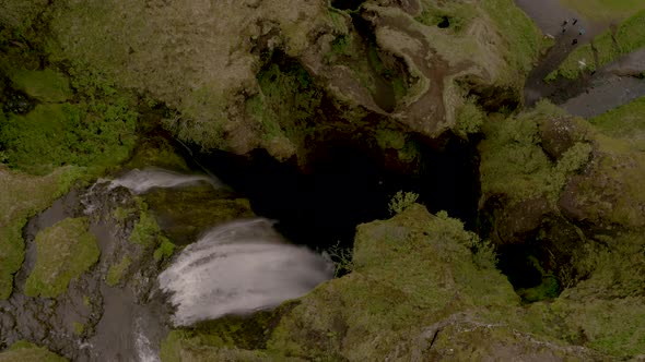 Aerial view overlooking a hidden waterfall gorge, in cloudy Iceland - Gljufrabui - top down drone sh