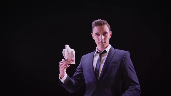 Young Magician with a White Dove. Young Handsome Brunette Magician Man in Stage Costume with His