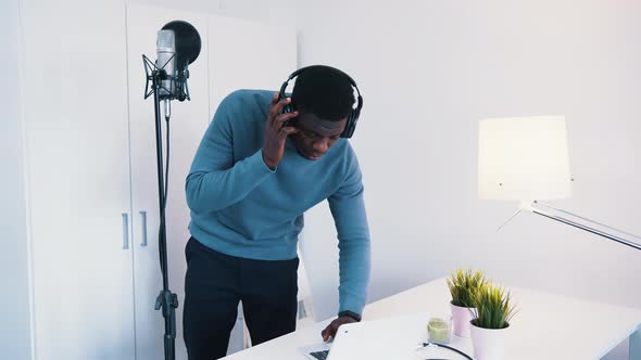 Man Wearing Headphones Standing in Front of a Microphone  Recording A Song