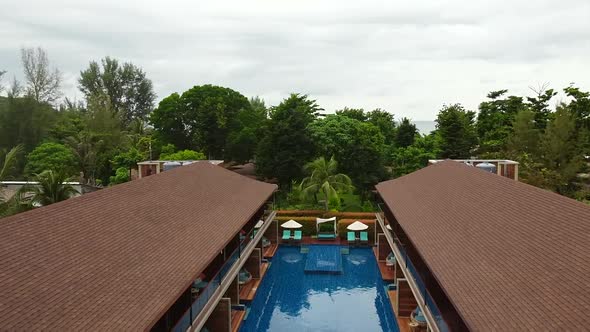 Aerial View Drone Flying Over Swimming Pool and Modern Houses with Wooden Roofs