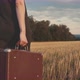 Female Carrying A Suitcase In A Field - VideoHive Item for Sale