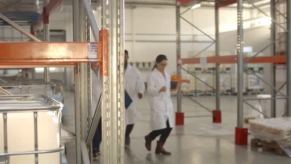 Multiethnic Warehouse Workers Team in White Coats Smiling and Dancing