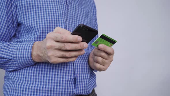 Closeup of Man Hands Holding Credit Card and Using Smartphone