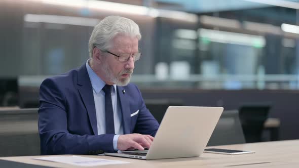 Old Businessman Working on Laptop in Office