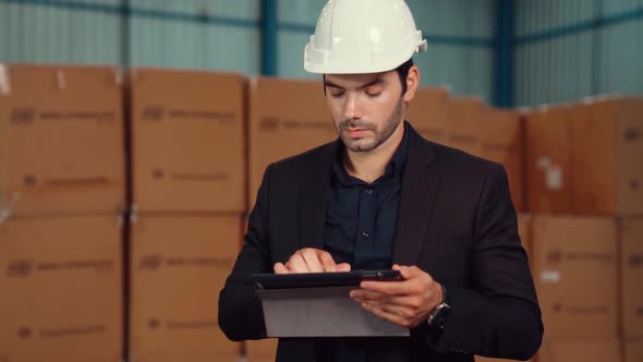 Factory Manager Using Tablet Computer in Warehouse or Factory