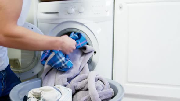 Man putting dirty clothes into washing machine