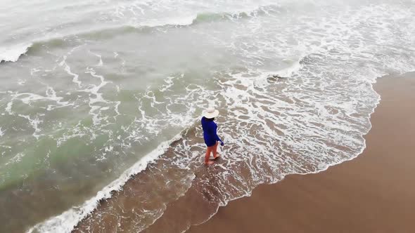 Woman in Blue Dress Walking Into the Water By Sand Beach on the Seaside on Sunset, Inspirational