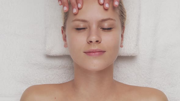 Young, healthy and beautiful woman gets massage therapy in the spa salon.