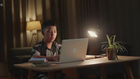 Asia Boy Use Laptop Computer At Home, Teenage Boy Learning Online From Laptop At Night