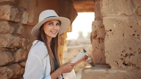 Woman Using Map and Brush During Archeological Expedition