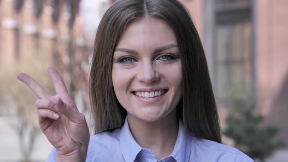 Victory Sign By Positive Young Woman