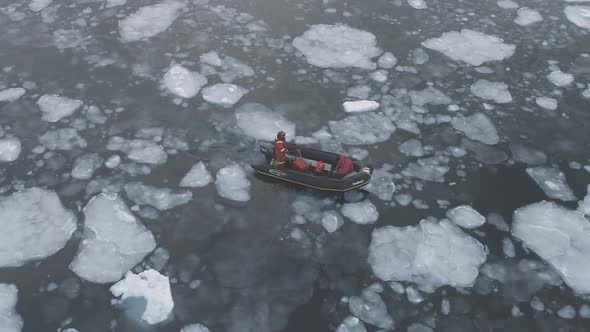 People in Expedition Boat Sail in Obstacles Brash Ice. Top Down Aerial View