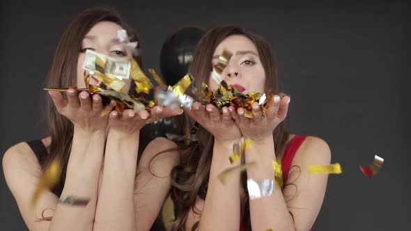 Two Attractive Sisters Giving Air Kiss To Camera