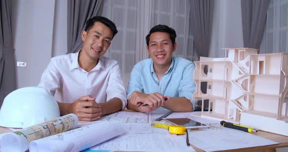 Two Asian Architects Smiling And Looking At Camera