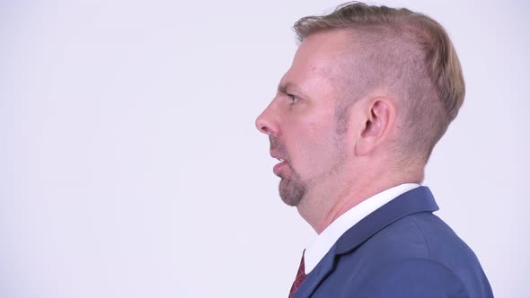 Head Shot Profile View of Angry Blonde Businessman Shouting