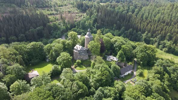 down tilting drone footage of the wildenburg castle  in the southeast of the village of Friesenhagen