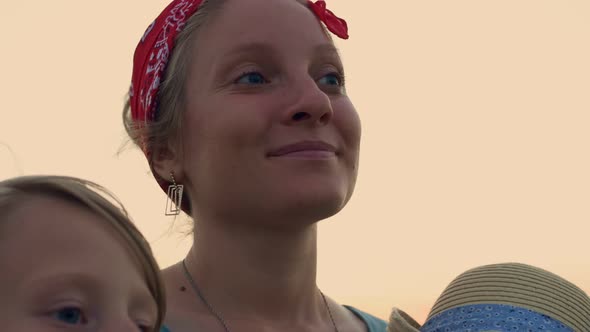 Closeup Face of a Beautiful Mother Who Stands in an Embrace with Her Children in the Rays of the