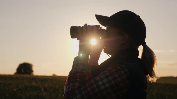 Silhouette of a Woman Looking Forward Through Binoculars