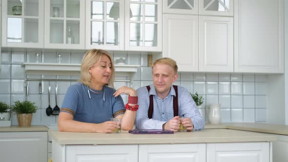 Woman with Adult Son Watching Photos on Tablet PC