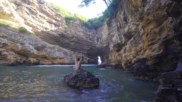 Young man vacationing in beach coastal cave.