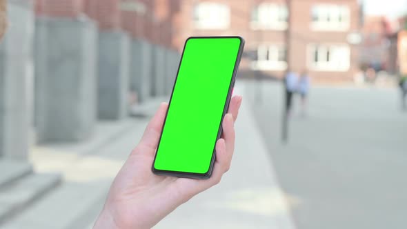 Woman Looking at Smartphone with Green Chroma Screen