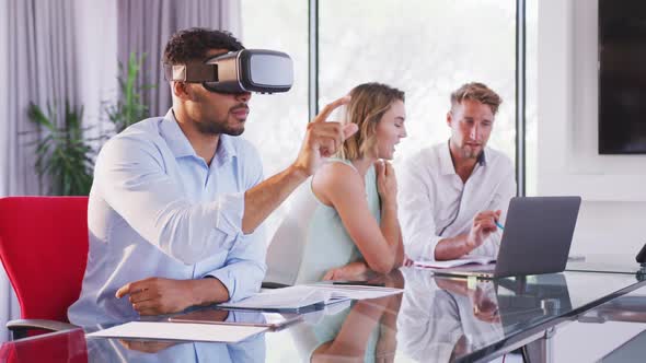 Professional businesswoman using virtual reality headset while sitting in office in slow motion