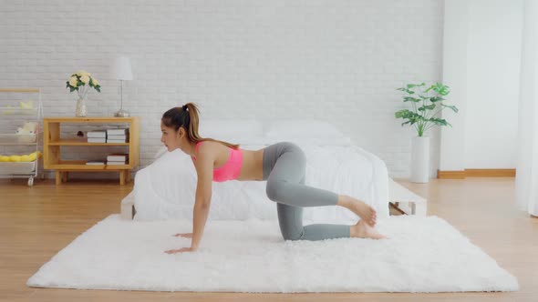 Athletic Healthy Asian woman in sportswear workout excercise at home