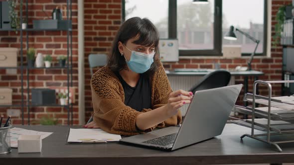 Entrepreneur Checking Rate Charts on Paper and Laptop