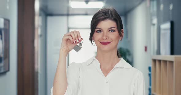 The Woman Shows the Keys to the Apartment and Smiles