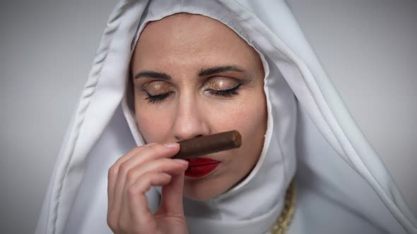 Front View Headshot of Caucasian Nun Smelling Cigar Looking at Camera Smiling