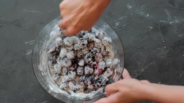 The process of making a blackberry pie. Berries sprinkled with powdered sugar