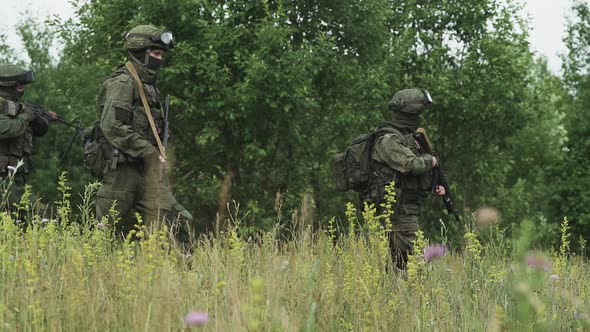 Soldiers in Camouflage with Assault Rifle Walking Through the Field Military Action in the Steppe
