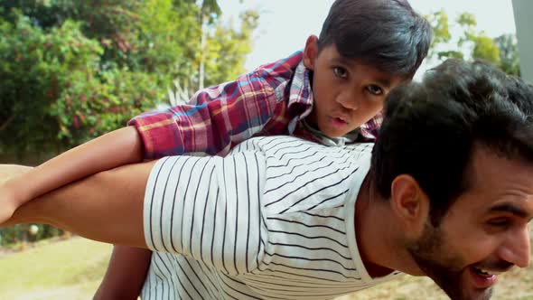 Father giving piggyback ride to his son