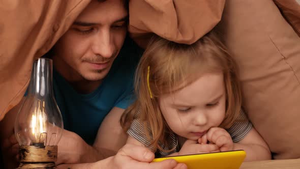 Father and Daughter Watch Cartoon on Phone Home Interior Training