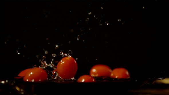 Cherry tomatoes falling in water, Ultra Slow Motion