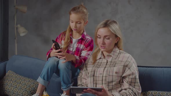 Mother and Daughter Networking with Gadgets at Home