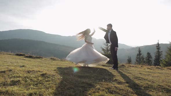 Newlyweds. Caucasian Groom with Bride Dancing on Mountain Slope. Wedding Couple