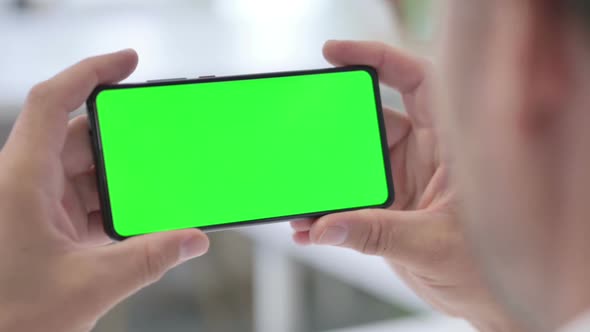 Man Looking at Smartphone with Green Chroma Screen, Close up