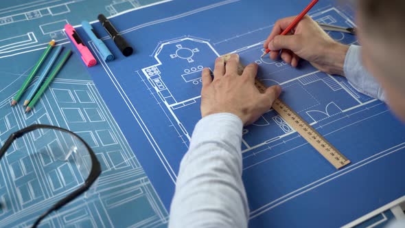 Architect Drawing Blueprints In Office